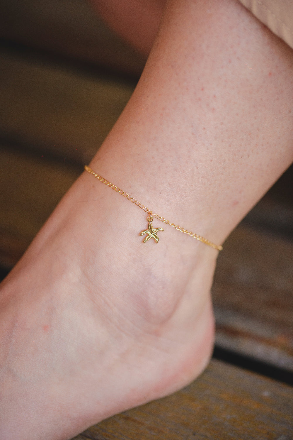 TORNOZELEIRA COM PINGENTE ESTRELA DO MAR FOLHEADO A OURO 18K