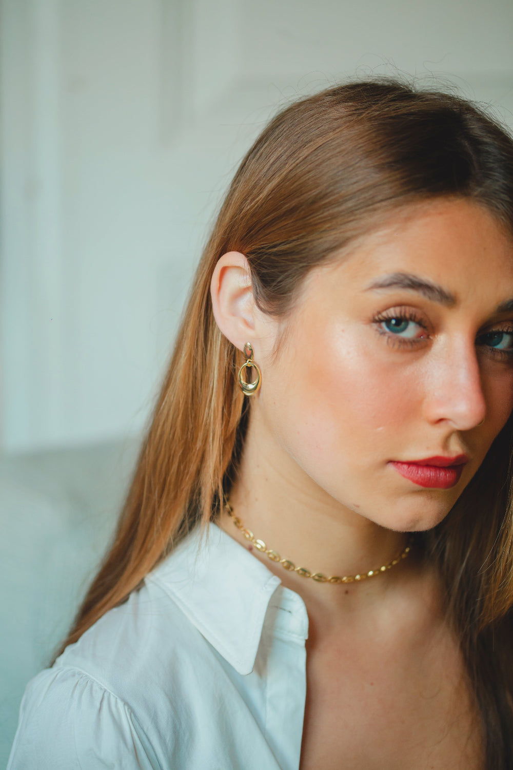 BRINCO LISO COM PÊNDULO OVAL PEQUENO FOLHEADO A OURO 18K