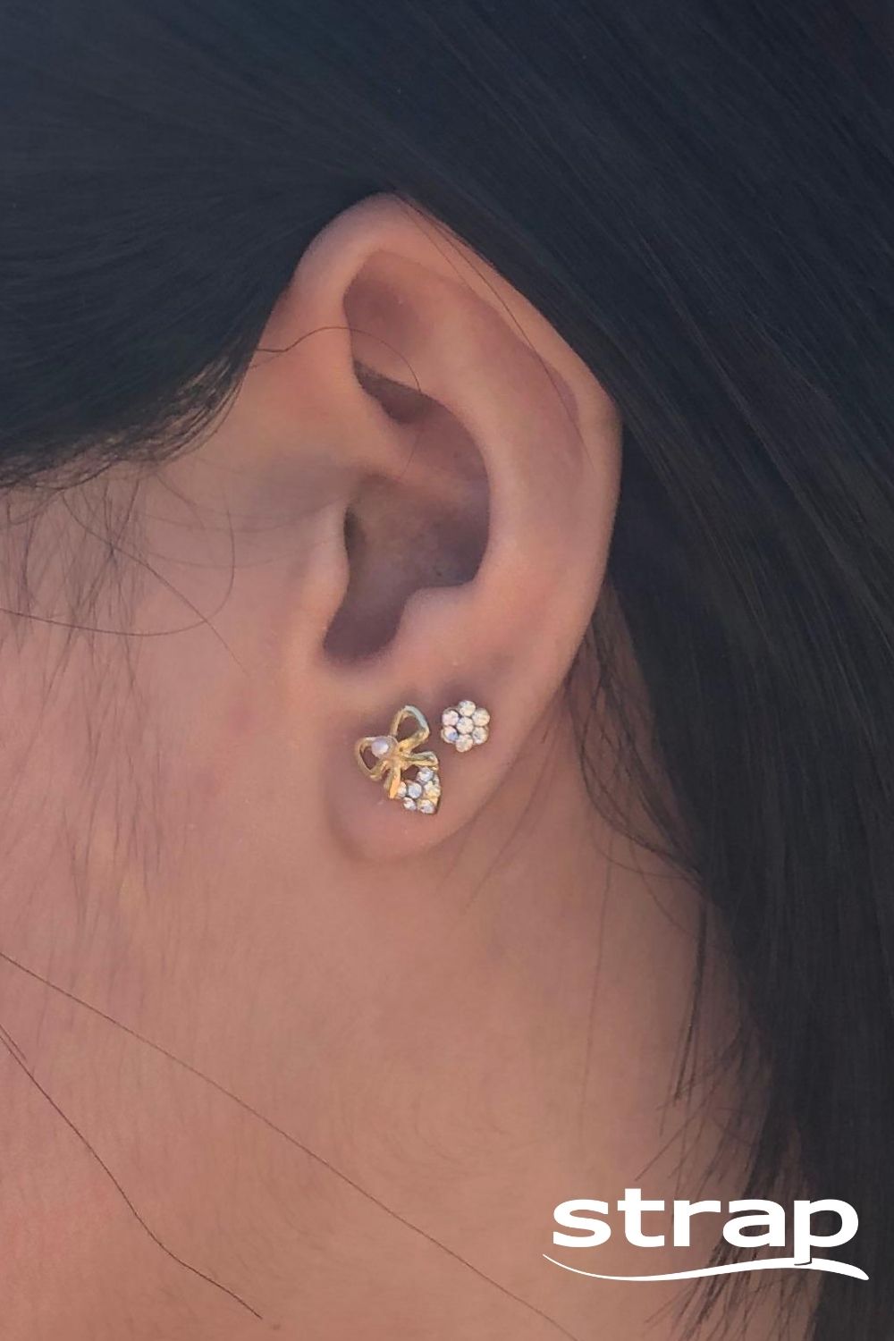 BRINCO MINI LAÇO COM PÉROLA E CORAÇÃO COM STRASS FOLHEADO A OURO 18K