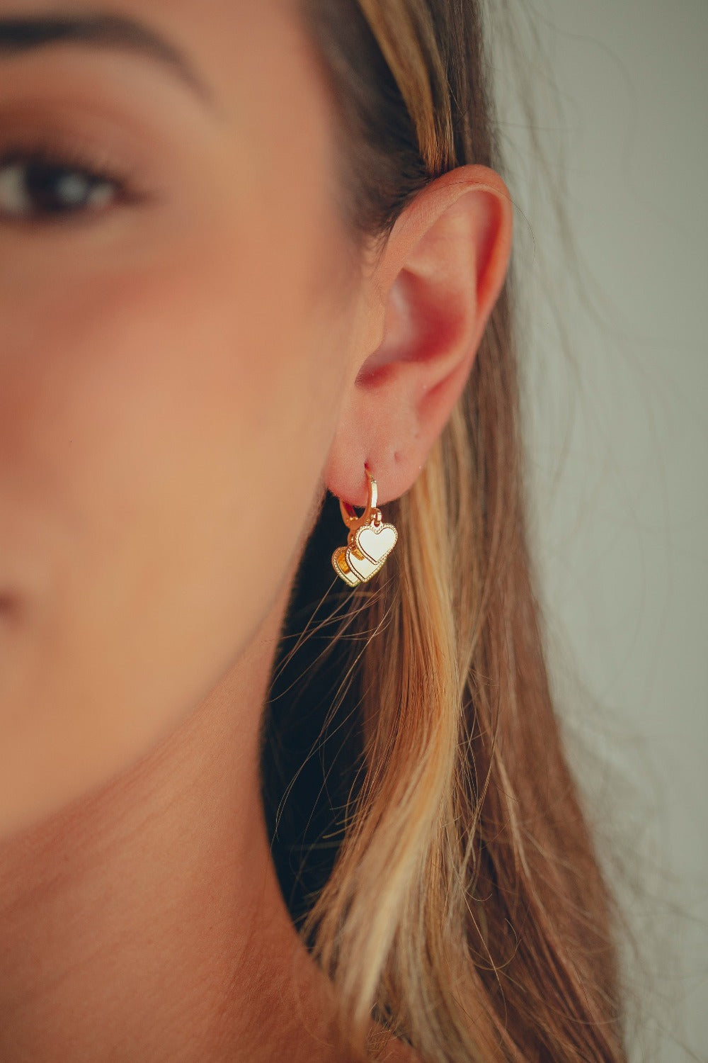 BRINCO DE ARGOLA COM TRÊS PINGENTES DE CORAÇÃO FOLHEADO A OURO 18K