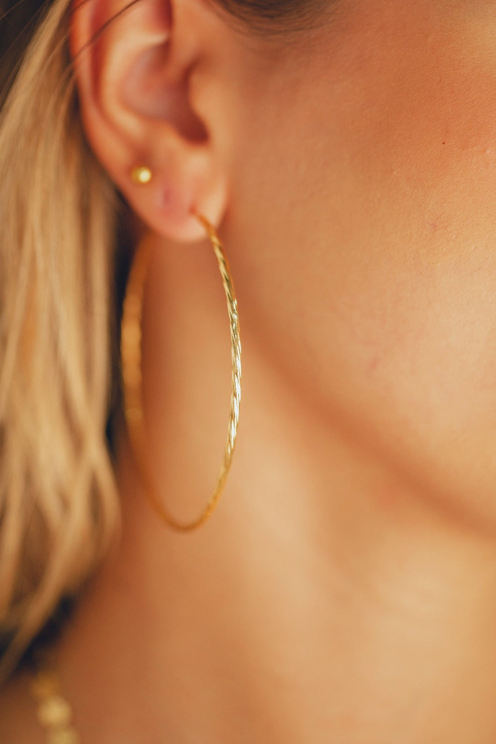 BRINCO DE ARGOLA FECHADA EM TUBO TORCIDO COM 6,5 CM DE DIÂMETRO FOLHEADO A OURO 18K